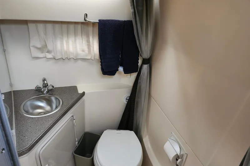 Slide: The Image of Interior of 2011 Regal 3060 Express Cruiser with wooden door and beige seating. - 37