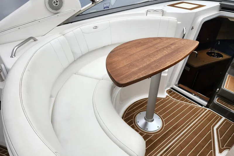 Slide: The Image of Interior of 2011 Regal 3060 Express Cruiser with helm, wooden table, and seating. - 4