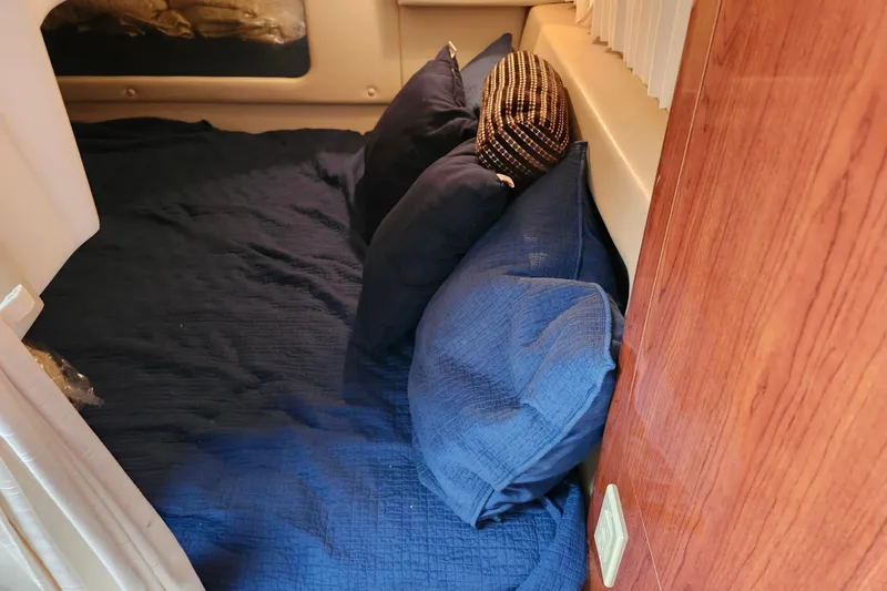 Slide: The Image of Cozy cabin interior of 2011 Regal 3060 Express Cruiser with blue bedding and striped cushions. - 41