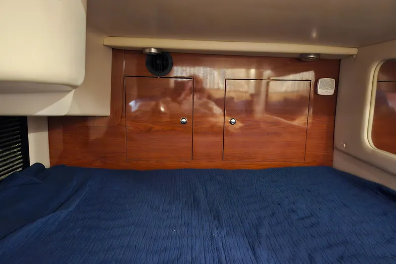 Slide: The Image of Cozy cabin interior of 2011 Regal 3060 Express Cruiser with blue bedding. - 42