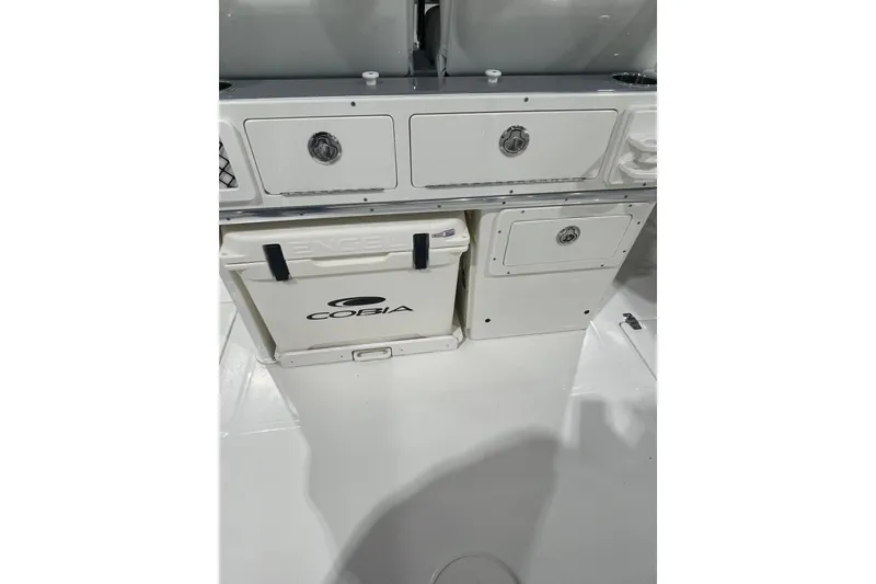 Slide: The Image of 2026 Cobia 285 Open Center Console boat interior with storage compartments and cooler. - 10
