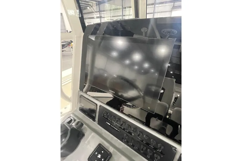Slide: The Image of 2026 Cobia 285 Open Center Console dashboard with modern navigation display. - 13
