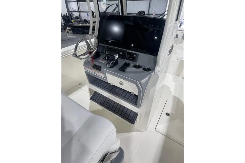 Slide: The Image of 2026 Cobia 285 Open Center Console boat interior with steering wheel and control panel. - 14