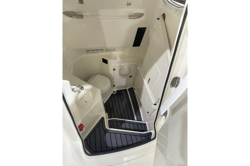 Slide: The Image of Interior of 2026 Cobia 285 Open Center Console boat, featuring compact bathroom amenities. - 16