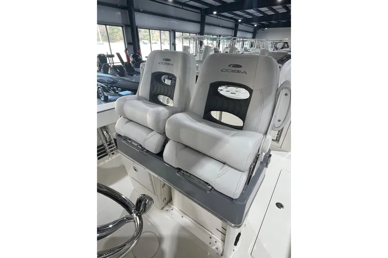 Slide: The Image of 2026 Cobia 285 Open Center Console boat seats in showroom, featuring sleek design and comfort. - 18