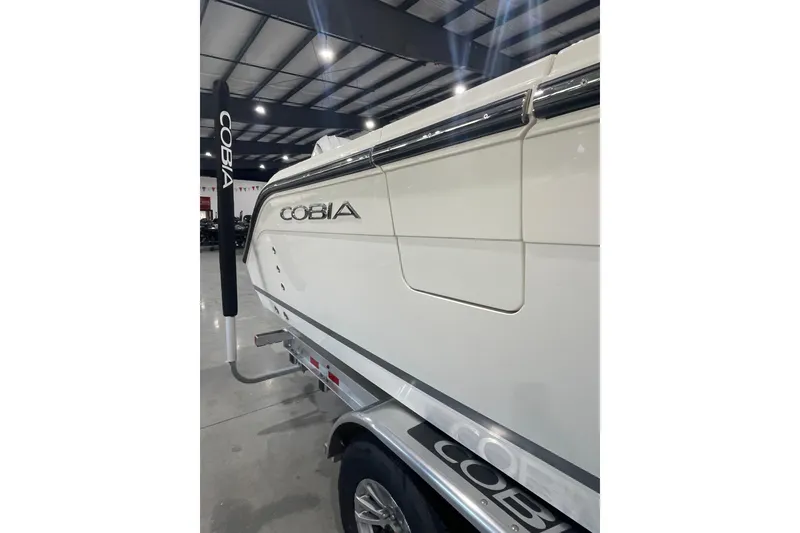 Slide: The Image of 2026 Cobia 285 Open Center Console boat in showroom, side view. - 2