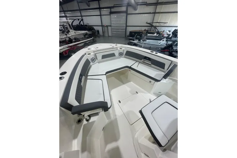 Slide: The Image of 2026 Cobia 285 Open Center Console boat interior with seating and storage in showroom. - 21
