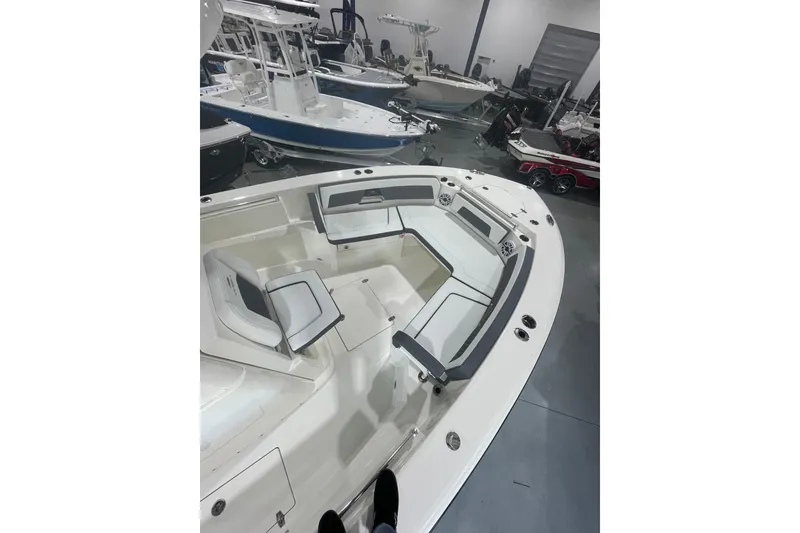 Slide: The Image of 2026 Cobia 285 Open Center Console boat interior with seating, displayed in a showroom. - 23