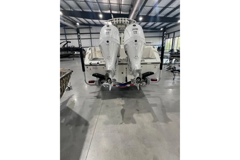 Slide: The Image of 2026 Cobia 285 Open Center Console with dual outboard engines in a showroom. - 4