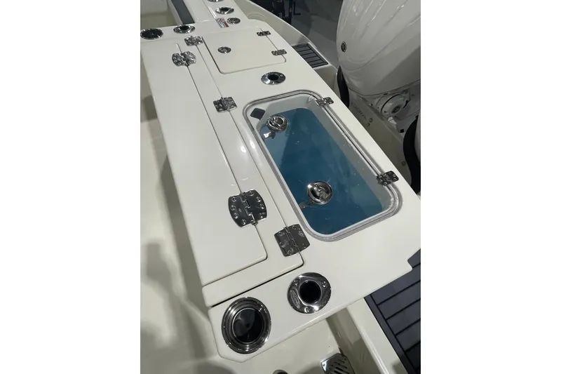 Slide: The Image of 2026 Cobia 285 Open Center Console boat deck with storage compartments and livewell. - 7