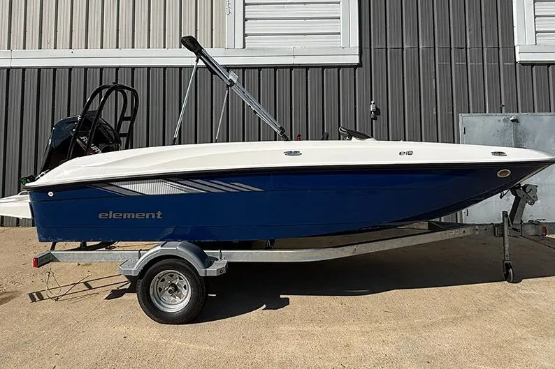 The Image of 2026 Bayliner Element E18 boat on trailer, blue and white design, parked outdoors. - 0