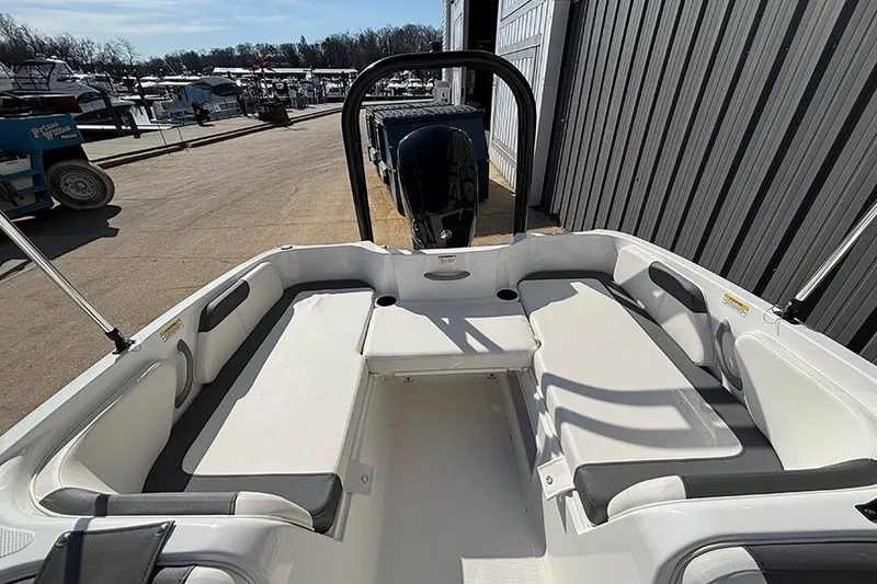 Slide: The Image of 2026 Bayliner Element E18 boat interior with seating, docked near marina. - 12