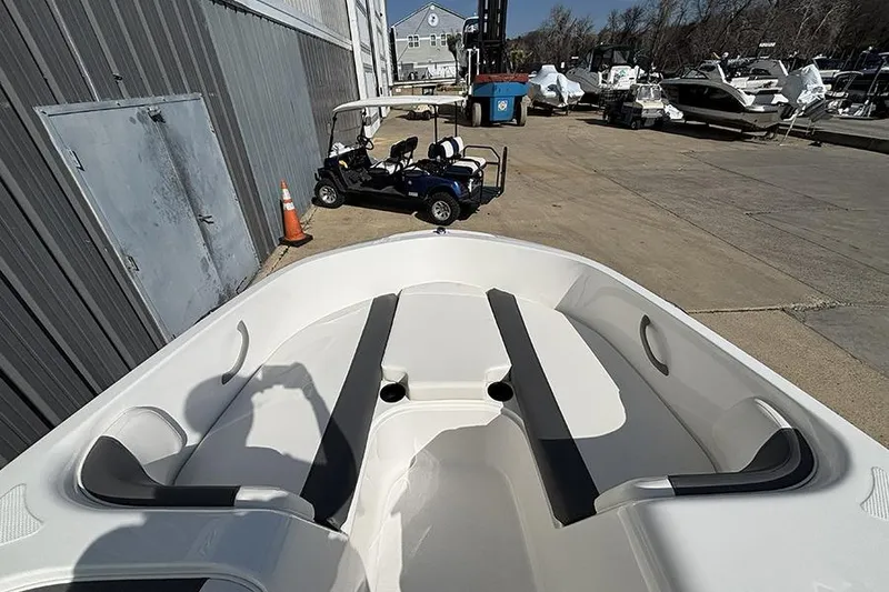 Slide: The Image of 2026 Bayliner Element E18 boat interior at a marina with golf cart nearby. - 20