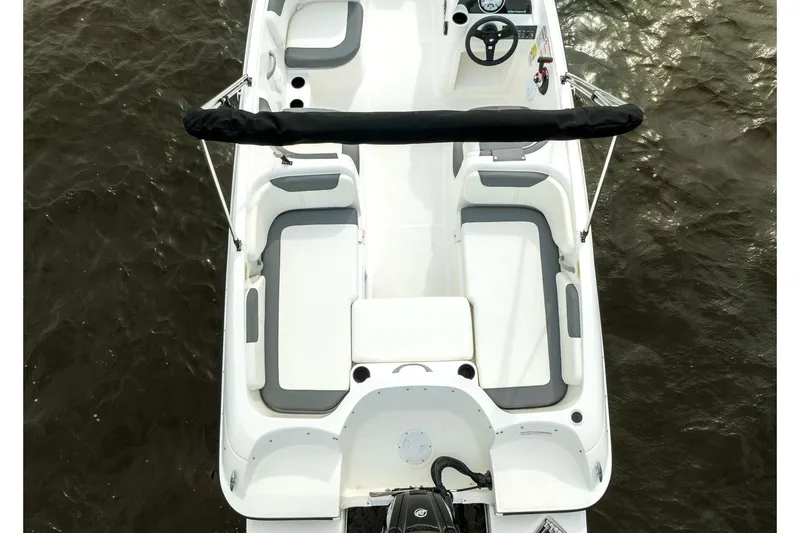 Slide: The Image of 2026 Bayliner Element E18 boat interior with steering wheel and seating at marina. - 6