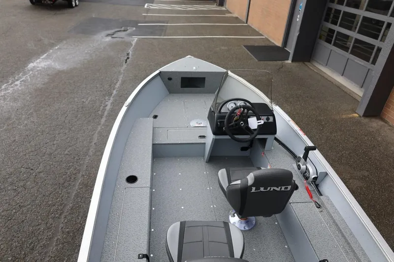 Slide: The Image of 2026 Lund 1600 Fury SS boat interior with steering wheel and seating. - 16