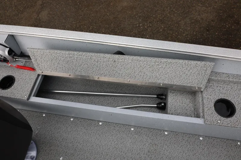 Slide: The Image of 2026 Lund 1600 Fury SS boat storage compartment with rods and textured flooring. - 19