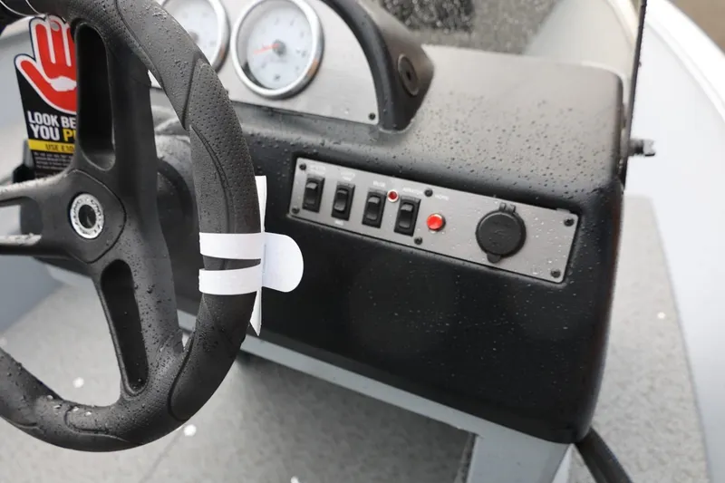 Slide: The Image of 2026 Lund 1600 Fury SS boat dashboard with steering wheel and control panel. - 21