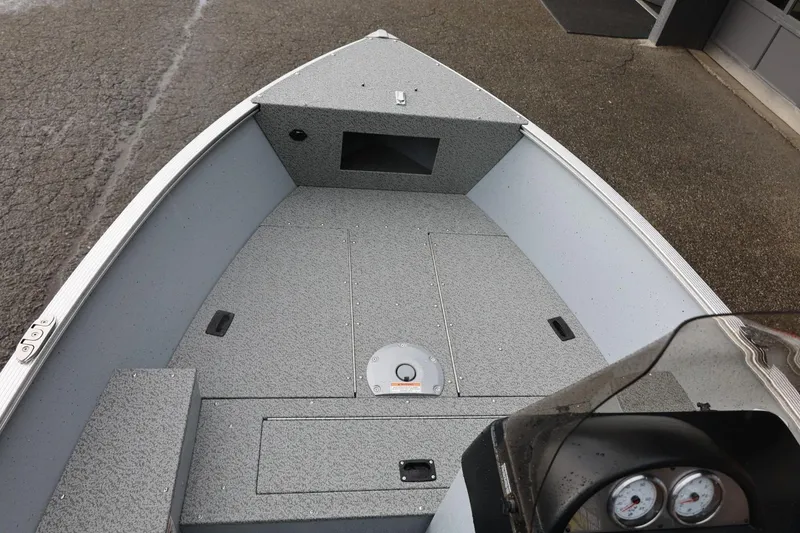 Slide: The Image of 2026 Lund 1600 Fury SS boat interior with gray deck and storage compartments. - 25