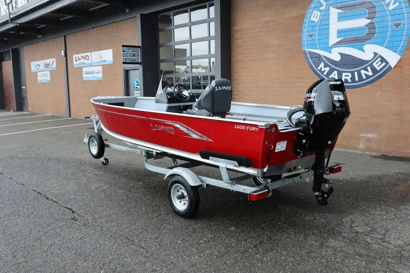 Slide: The Image of 2026 Lund 1600 Fury SS boat in red, parked on a trailer outside a marine shop. - 3