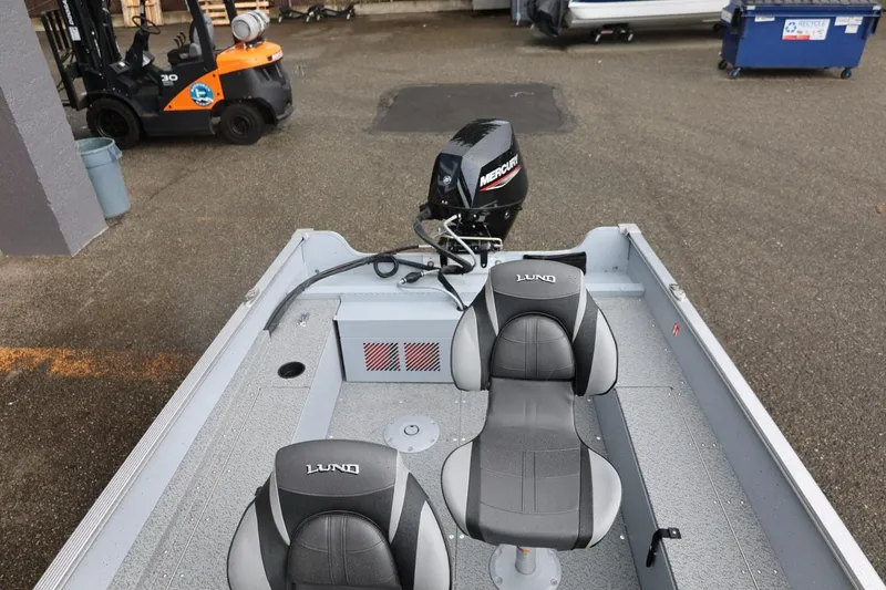 Slide: The Image of 2026 Lund 1600 Fury SS boat with Mercury motor and dual seats in a parking area. - 31