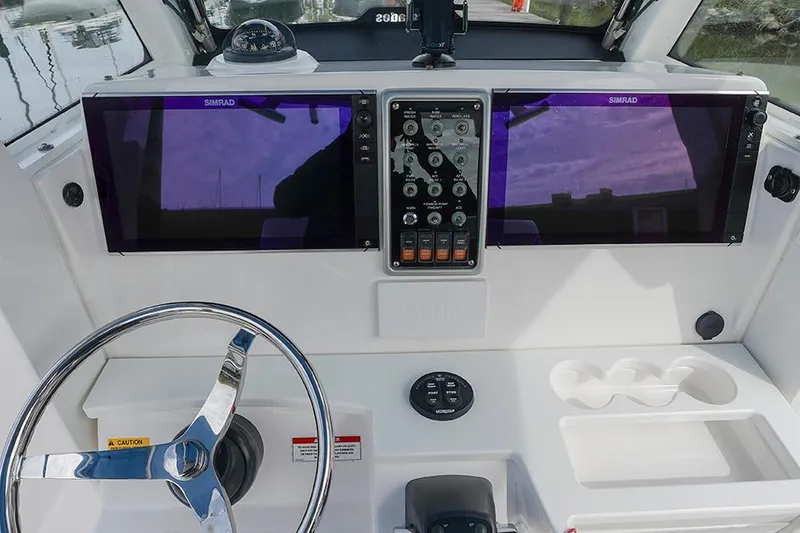 Slide: The Image of 2015 Everglades 295 Center Console dashboard with dual Simrad displays and steering wheel. - 12
