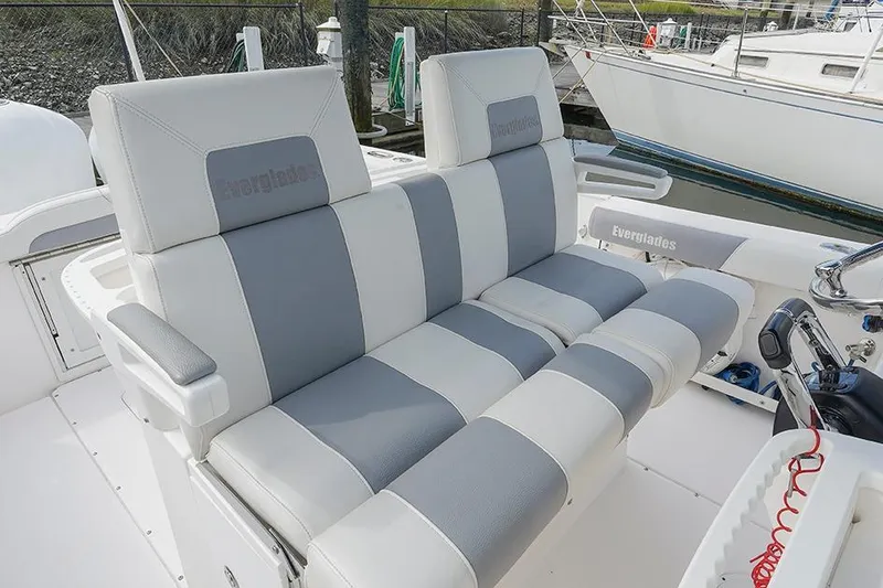 Slide: The Image of 2015 Everglades 295 Center Console boat seating, featuring gray and white cushioned seats. - 19