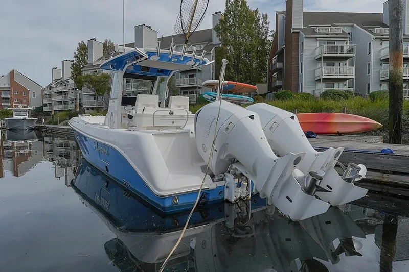 Slide: The Image of 2015 Everglades 295 Center Console boat docked near waterfront buildings. - 2