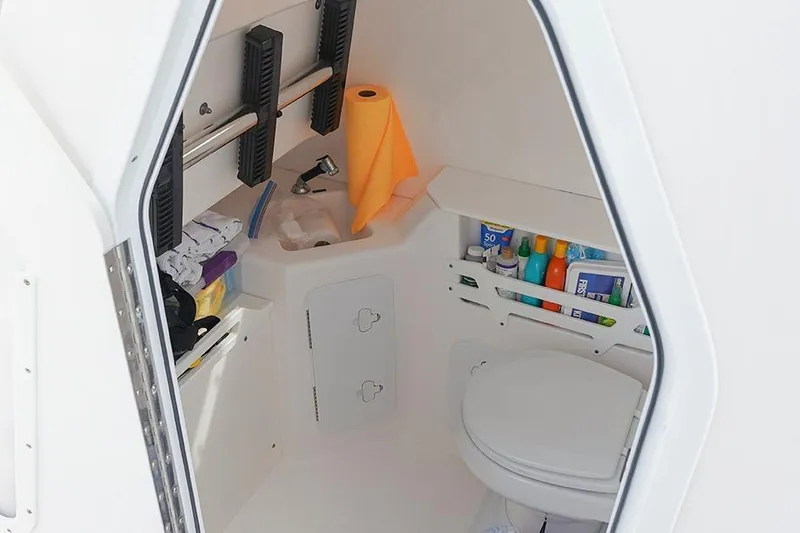 Slide: The Image of 2015 Everglades 295 Center Console boat interior with toilet and storage shelves. - 26