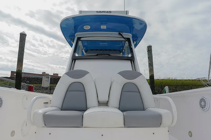 Slide: The Image of 2015 Everglades 295 Center Console boat with cushioned seating and blue canopy. - 8