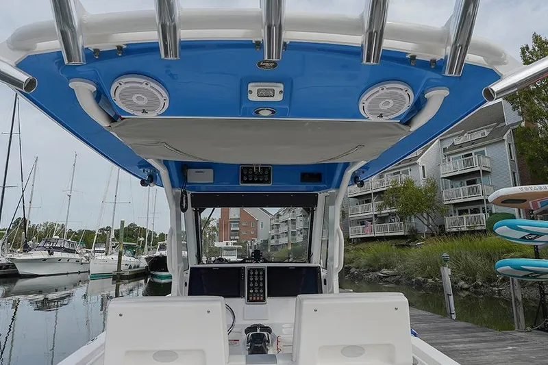 Slide: The Image of 2015 Everglades 295 Center Console boat interior at marina, featuring blue canopy and control panel. - 9