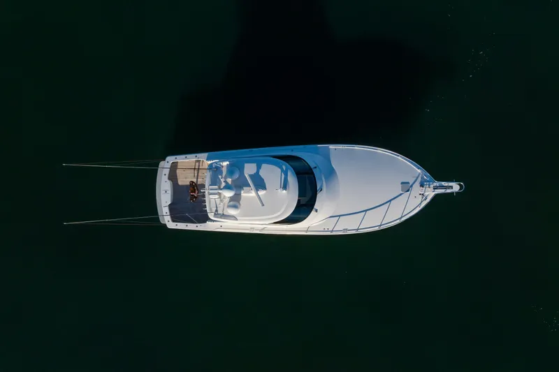 Slide: The Image of Aerial view of 2022 Viking 54 Sport Coupe yacht on dark water. - 15