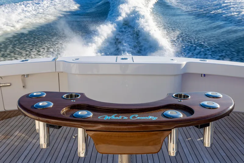 Slide: The Image of 2022 Viking 54 Sport Coupe yacht with custom fishing rod holder, cruising on open water. - 18