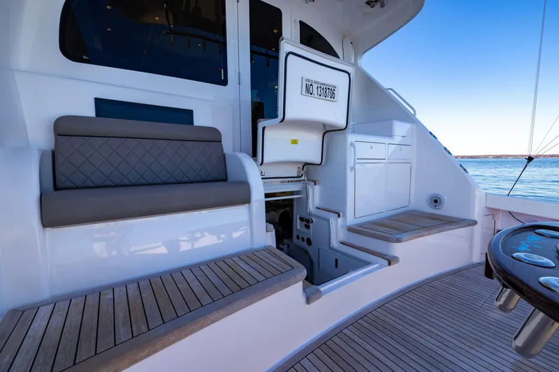 Slide: The Image of 2022 Viking 54 Sport Coupe yacht interior with seating and storage, overlooking serene waters. - 22