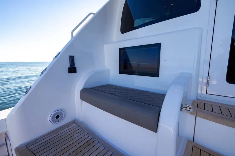 Slide: The Image of 2022 Viking 54 Sport Coupe interior with seating and screen, overlooking the ocean. - 26