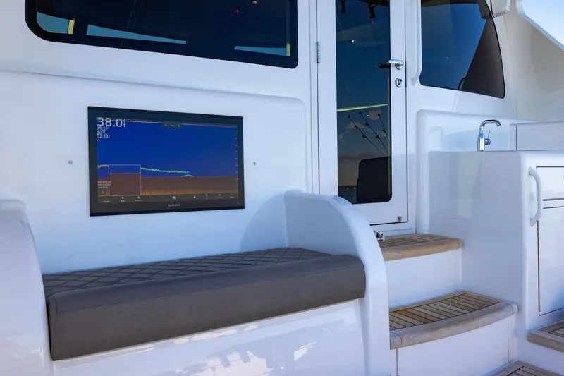 Slide: The Image of 2022 Viking 54 Sport Coupe interior with sonar display and cushioned seating. - 28