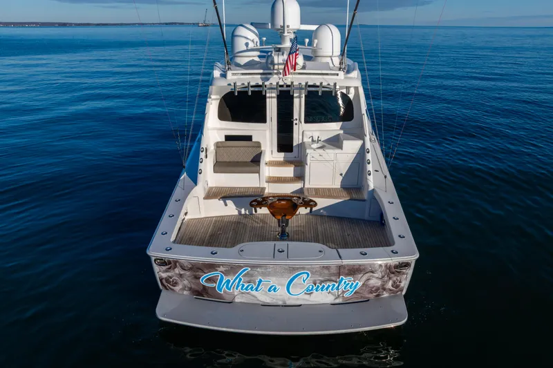 Slide: The Image of 2022 Viking 54 Sport Coupe yacht on calm blue waters, rear view. - 4