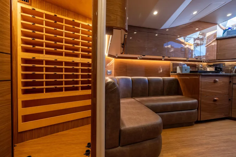 Slide: The Image of Luxurious interior of 2022 Viking 54 Sport Coupe yacht with leather seating and wooden cabinetry. - 53