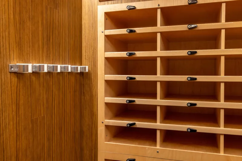 Slide: The Image of Wooden storage compartments inside a 2022 Viking 54 Sport Coupe yacht. - 55