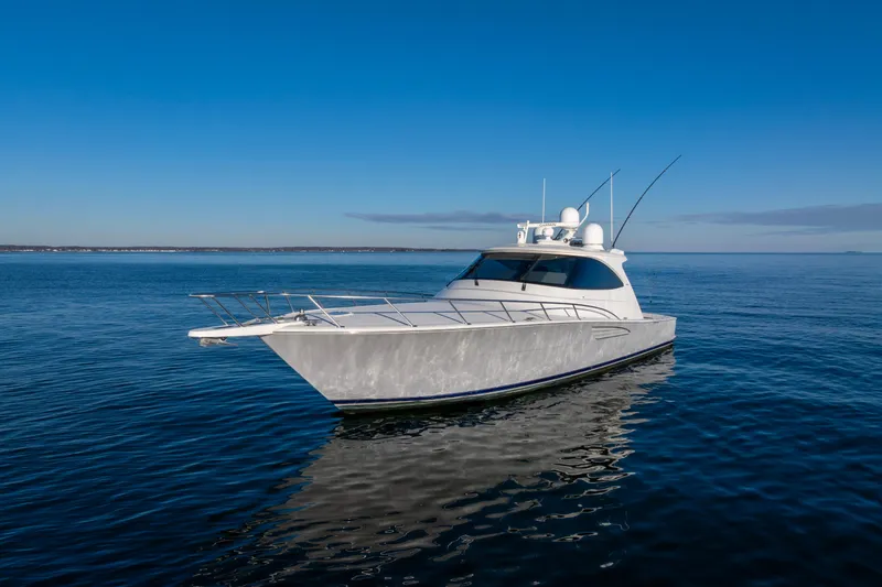 Slide: The Image of 2022 Viking 54 Sport Coupe yacht on calm blue ocean waters. - 7
