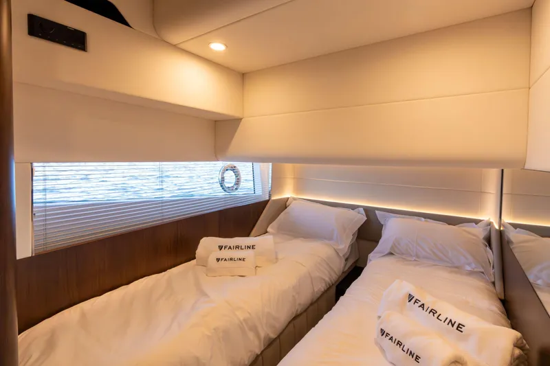 Slide: The Image of Luxurious twin cabin in 2026 Fairline Squadron 58 yacht, featuring elegant bedding and ambient lighting. - 19