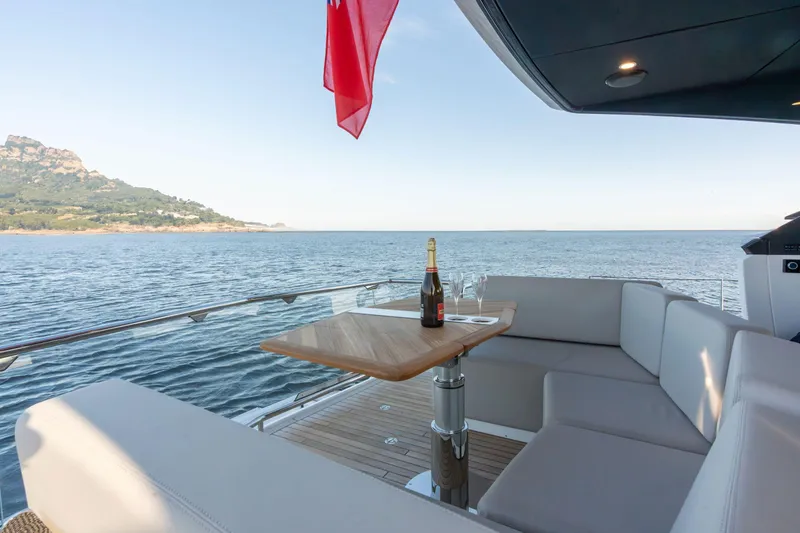 Slide: The Image of Luxury Fairline Squadron 58 yacht deck with seating, table, and ocean view, 2026 model. - 9