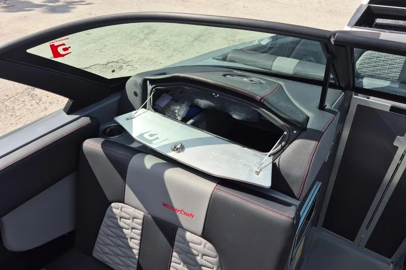 Slide: The Image of 2022 MasterCraft X24 boat interior with open storage compartment and seating. - 11