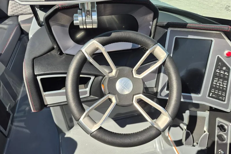 Slide: The Image of 2022 MasterCraft X24 boat dashboard with modern steering wheel and control panel. - 22