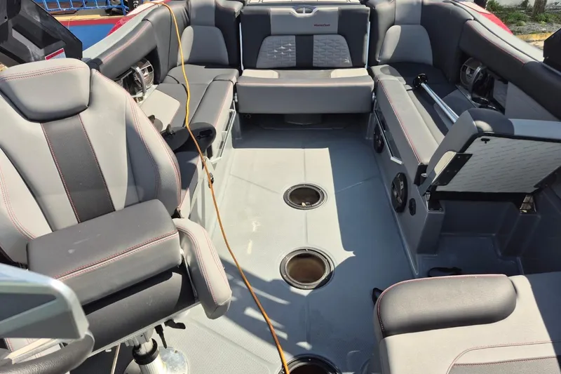 Slide: The Image of Interior of a 2022 MasterCraft X24 boat with gray seating and cup holders. - 23