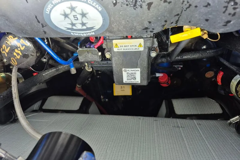 Slide: The Image of Engine compartment of a 2022 MasterCraft X24 boat, featuring Ilmor components and emission label. - 27