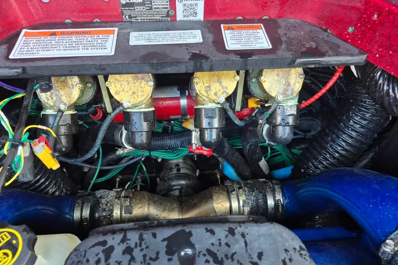 Slide: The Image of Engine compartment of a 2022 MasterCraft X24 boat, showing mechanical components and wiring. - 28