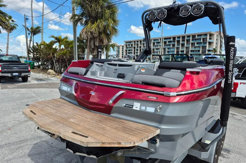 Slide: The Image of 2022 MasterCraft X24 boat with sleek design, docked near palm trees and buildings. - 4