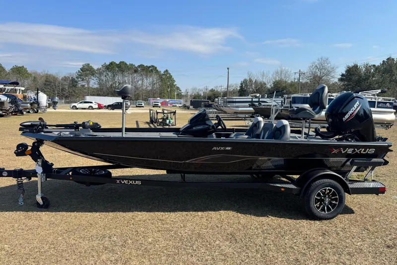 Slide: The Image of 2026 Vexus Defender 181 boat on trailer, parked outdoors, side view. - 2