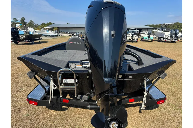 Slide: The Image of 2026 Vexus Defender 181 boat, rear view with motor, displayed outdoors. - 5