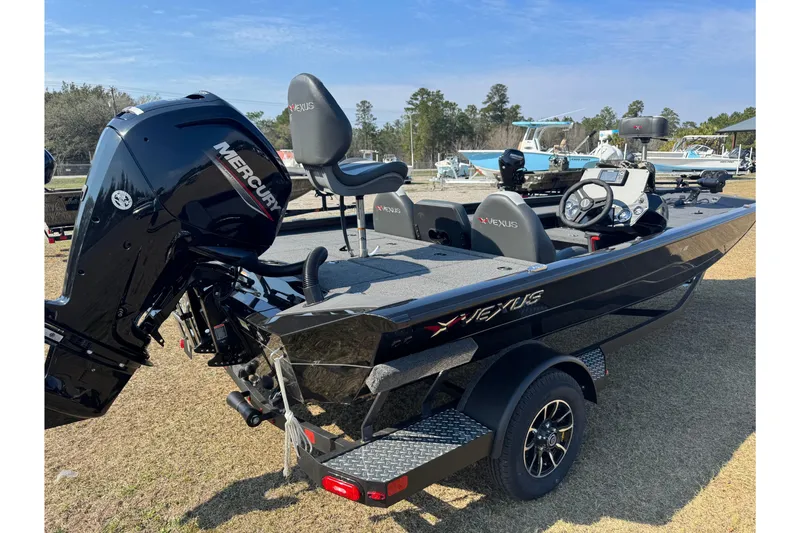 Slide: The Image of 2026 Vexus Defender 181 boat with Mercury engine, parked on grass. - 6